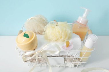 Bebek için hediye sepeti mavi duvarın yanındaki masada, yakın plan.