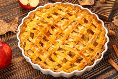 Ahşap arka planda lezzetli elmalı turta ve tarçınlı fırın yemeği.