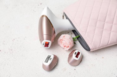 Modern fotoepilatör ve grunge beyaz arkaplan üzerinde güzel pembe gül eklentileri ile çanta