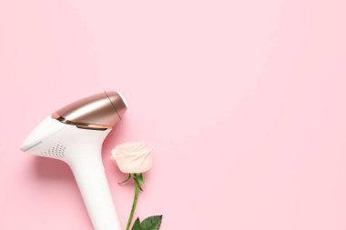 Pembe arka planda güzel bir gül çiçeği olan modern fotoepilatör.