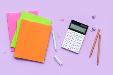 Okul malzemeleriyle birlikte eflatun arka planda kompozisyon