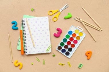 Renkli arka planda farklı okul malzemelerine sahip kompozisyon