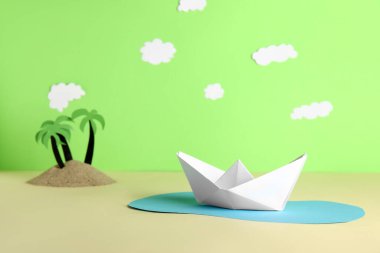 Renkli arkaplanda beyaz origami teknesi olan yaratıcı kompozisyon