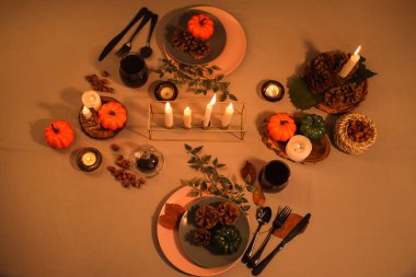 Sonbahar sofrası, balkabakları, yanan mumlar ve akşamları çam kozalakları.