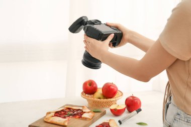 Stüdyoda nefis elmalı turtanın fotoğrafını çeken kadın fotoğrafçı.