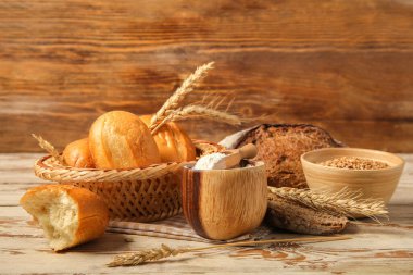 Buğday dikenli somunlar ve ahşap zemin üzerinde un.