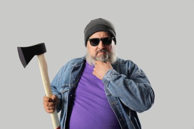 Gri arka planda baltası olan olgun oduncunun portresi