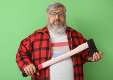 Yeşil arka planda baltası olan olgun oduncunun portresi