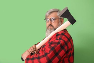 Yeşil arka planda baltası olan olgun oduncunun portresi