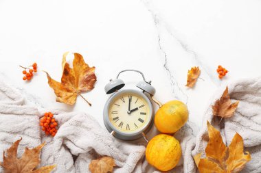 Alarm saati, balkabağı ve yapraklı sonbahar kompozisyonu beyaz arkaplanda