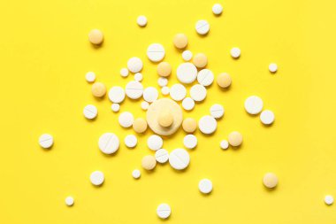 Sarı arka planda bir sürü farklı hap var.