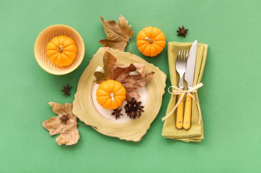 Balkabakları, yıldız anasonu ve yeşil arkaplanda kurumuş yapraklarla sonbahar masası ayarı