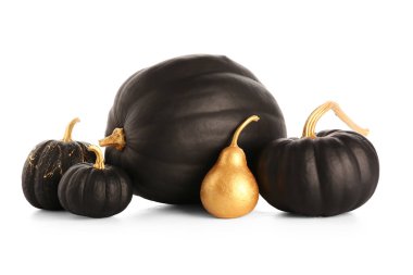 Siyah boyalı balkabakları ve beyaz arka planda altın armut.