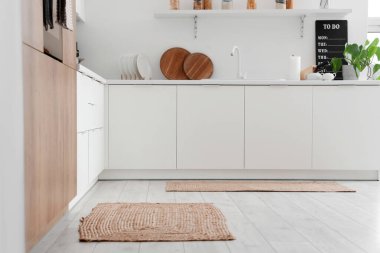 Mutfağın içinde tezgah ve hasır halılar var.