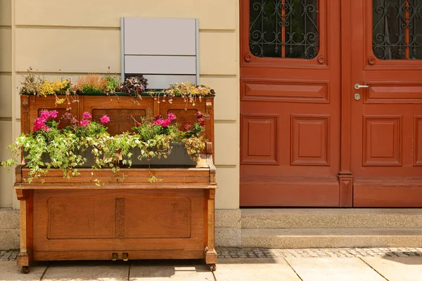 Old piano with flowers on street