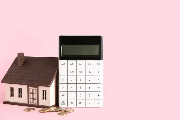 Calculator, house model and money on pink background. Mortgage concept