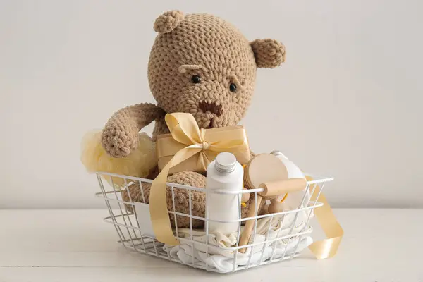 Gift basket for baby on light wooden table in room
