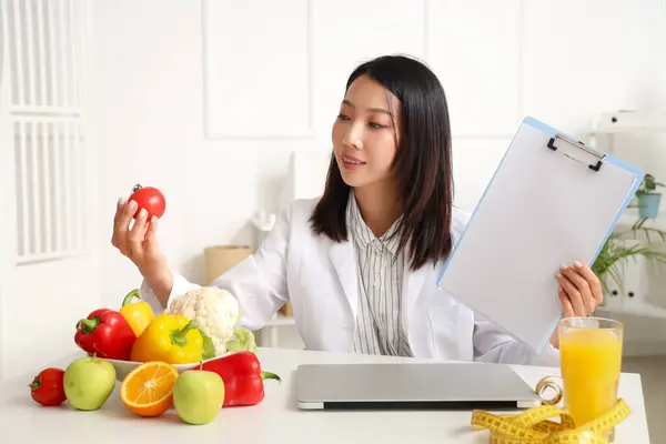 Vrouwelijke Aziatische Voedingsdeskundige Met Klembord Tomaat Aan Tafel Kantoor — Stockfoto
