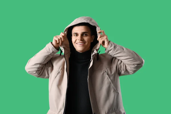 Yeşil Arka Planda Kışlık Elbiseli Genç Adam — Stok fotoğraf