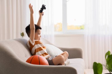 Evde video oyunu oynayan küçük Asyalı çocuk.