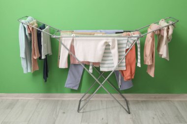 Kışlık giysileri olan kurutucu yeşil duvarın yanında.