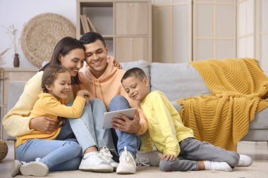 Evde tablet bilgisayar kullanan mutlu bir aile