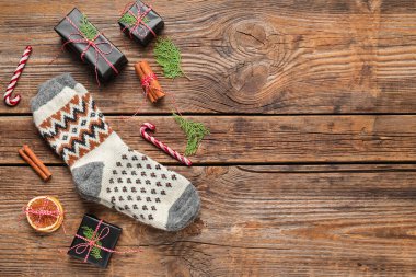 Noel hediye kutularıyla örülmüş çoraplar, tarçın ve tahta arka planda şeker kamışları.