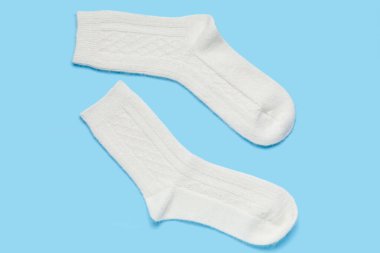 Mavi arka planda beyaz örülmüş çoraplar