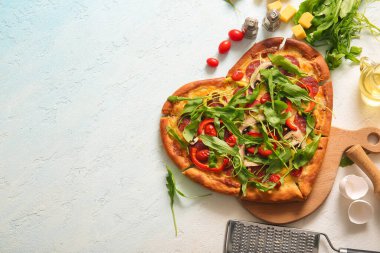 Lezzetli kalp şeklinde pizza ve açık mavi arka planda malzemeler olan ahşap tahta tahta tahta.