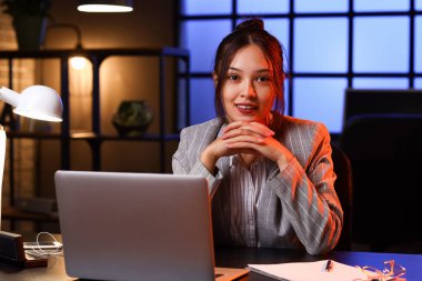 Genç Asyalı iş kadını geceleri ofiste çalışıyor.