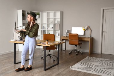 Dizüstü bilgisayarla çalışan kadın tasarımcı