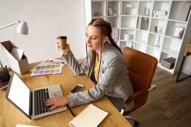 Ofiste çalışan kulaklıklı kadın tasarımcı.