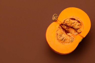 Kahverengi arka planda taze balkabağının yarısı