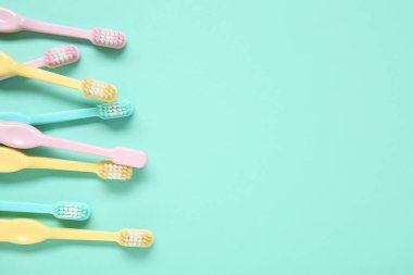 Renkli arkaplanda renkli plastik diş fırçaları.