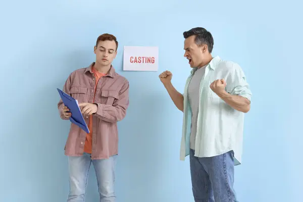 Male actors casting near blue wall