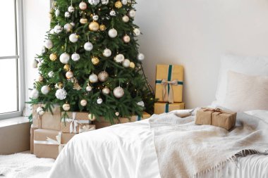 Konforlu yatağı ve Noel ağacı olan şenlikli bir yatak odası.