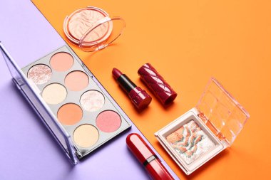 Güzel göz falı paletleri ve renkli arka planda farklı dekoratif kozmetikler.