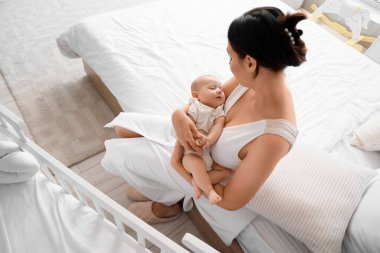 Mutlu anne ve küçük bebeği yatak odasında.