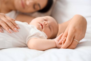 Anne ve küçük tatlı bebeği yatak odasında uyuyorlar.