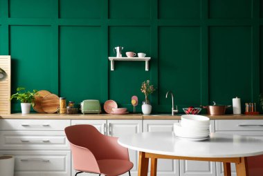 Beyaz tezgahlı ve yemek masalı modern mutfağın içi.