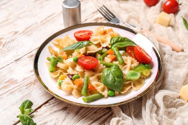 Beyaz ahşap arka planda lezzetli primavera makarnalı tabak.