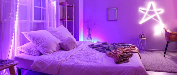 Interior of modern bedroom with neon lighting