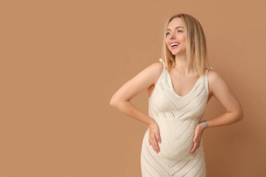 Mutlu hamile kadın bej arka planda