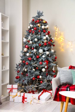 Oturma odasında hediyelerle parlayan Noel ağacı