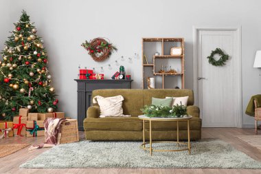 Oturma odasının içinde kanepe, Noel ağacı ve hediyeler.