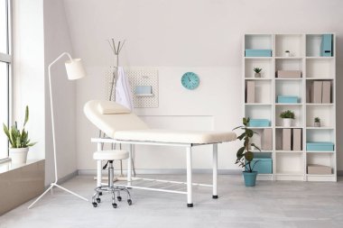 Koltuğu ve raf ünitesi olan hafif tıp bürosu.