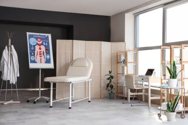 Çalışma yeri, kanepe ve katlama ekranı olan bir tıp bürosu.