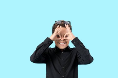 Komik küçük Afro-Amerikalı çocuk mavi arka planda iyi görünüyor.