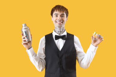 Titreyen ve sarı arka planda tekila içen genç bir barmen.