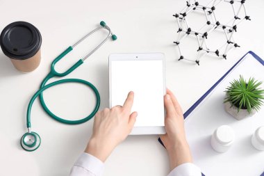 Tablet bilgisayarı olan kadın doktor, en üstte.